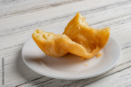 side view traditonal Chinese friedcake with bites on white wood background photo