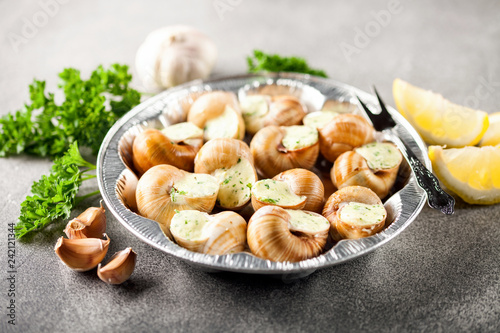 Escargots de Bourgogne - Snails with herbs butter on gray background. Selective focus
