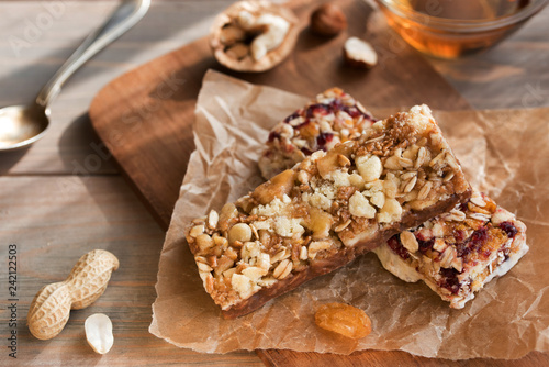 Granola bars with nuts and dried fruits and honey on wooden background- snack for healthy still live