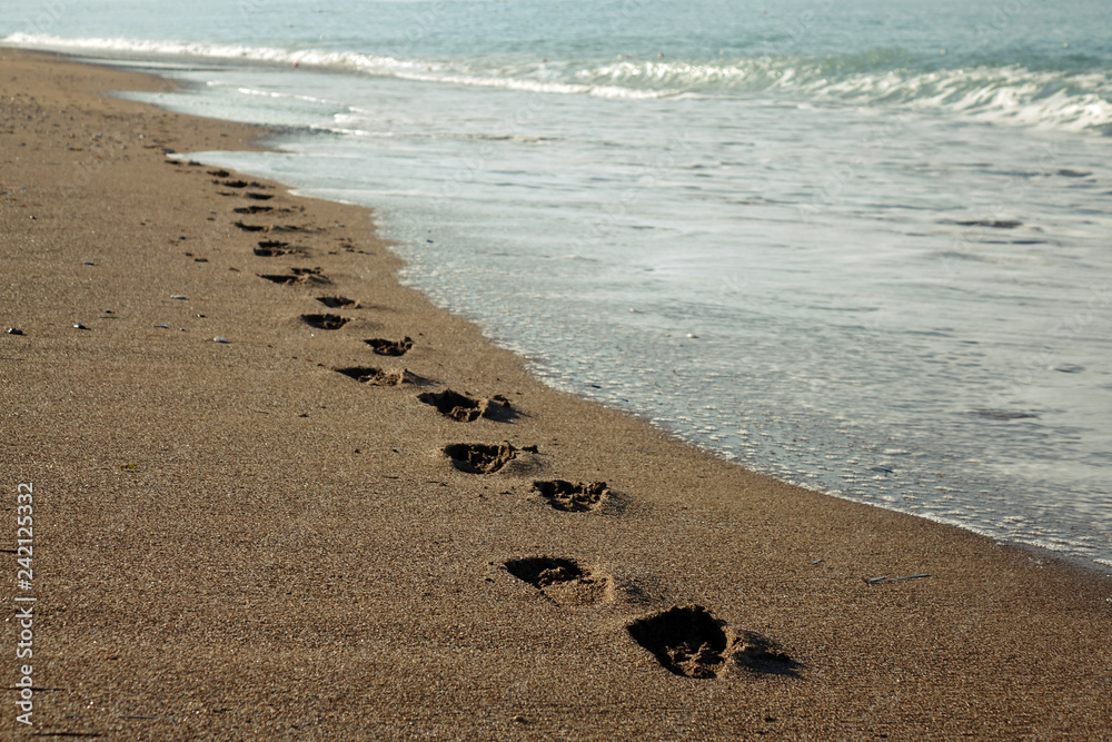 Footprints in the sand. Beach holiday. wave, ocean Footprints in the sand. Beach holiday. wave, ocean