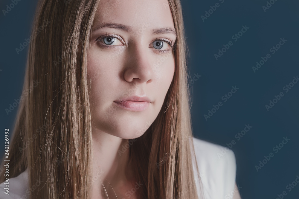 Naklejka premium portrait of young cute girl close up on blue background, beautiful girl