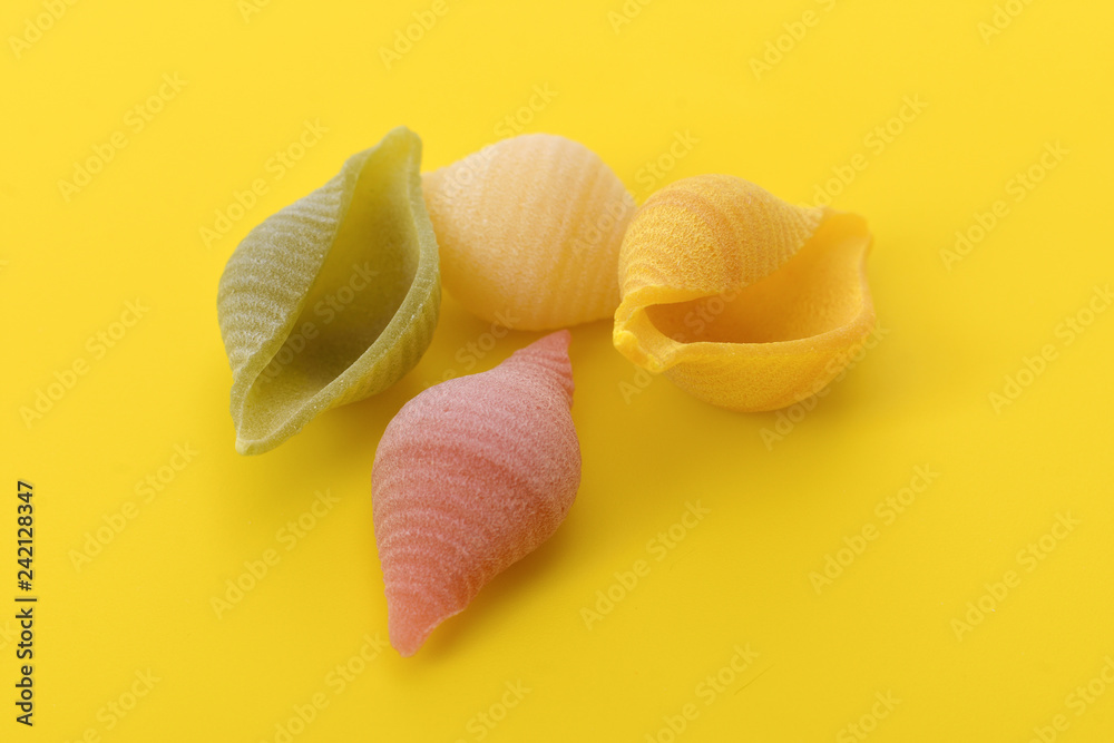 Pasta conchiglie on yellow background Pasta conchiglie on yellow background