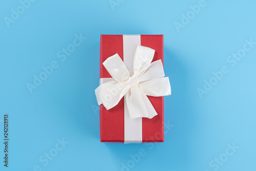 Red gift box with white ribbon bow, concept of giving present and Valentine's, anniversary, mother's day and birthday surprise, copy space, top view
