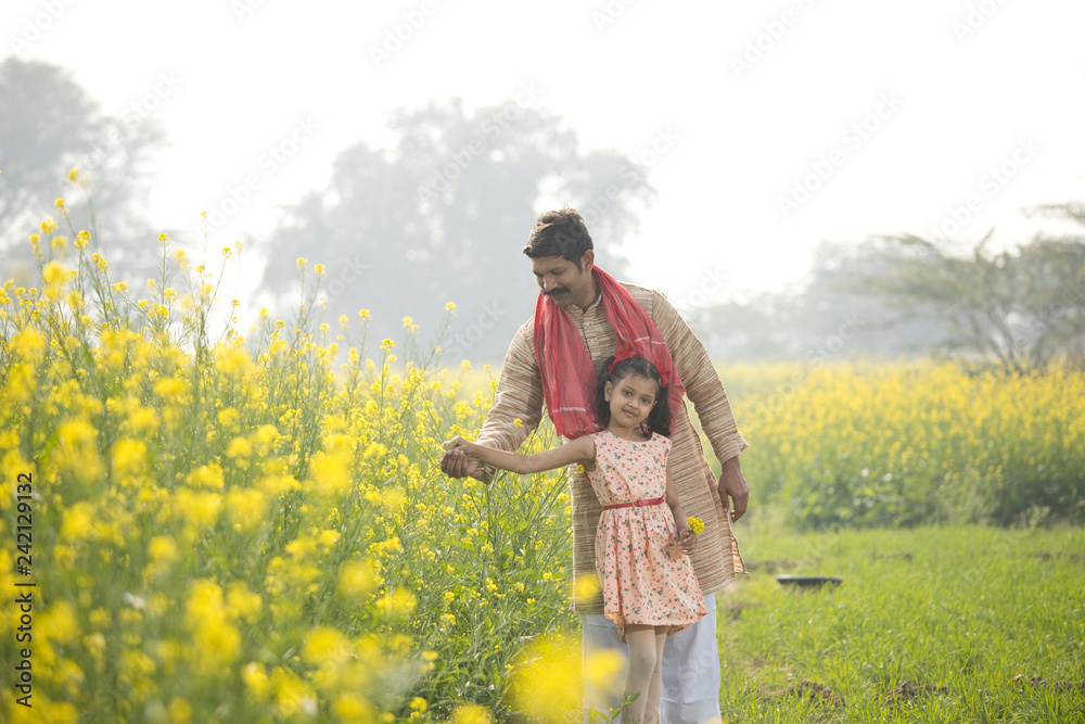 Rural farmer with her daughter on rapeseed field