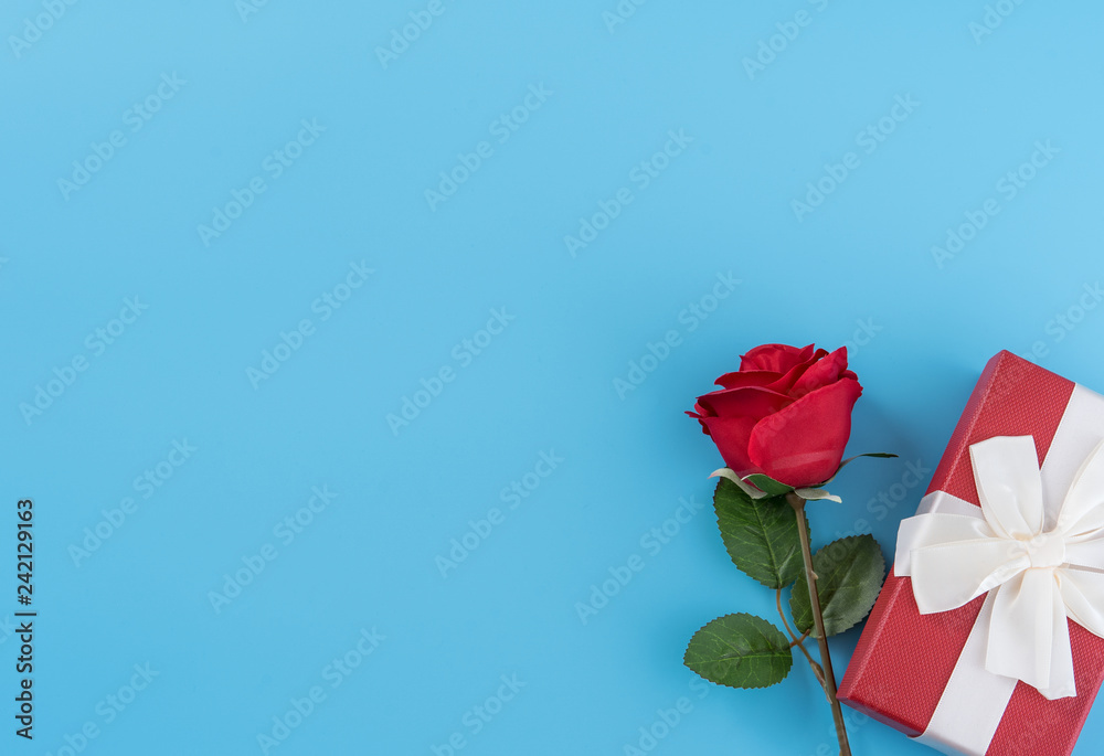 Red gift box with white ribbon bow and rose, concept of Valentine's day, anniversary, mother's day, birthday surprise present, copy space, top view
