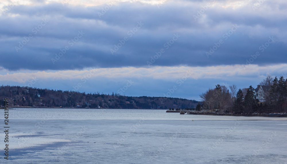 Winter landscape with sunset over frozen body of water, lake, river, cold, no people, Nova Scotia Winter landscape with sunset over frozen body of water, lake, river, cold, no people, Nova Scotia