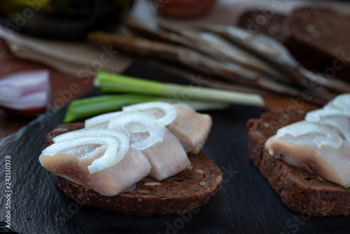 Sliced herring on rye bread with onion.