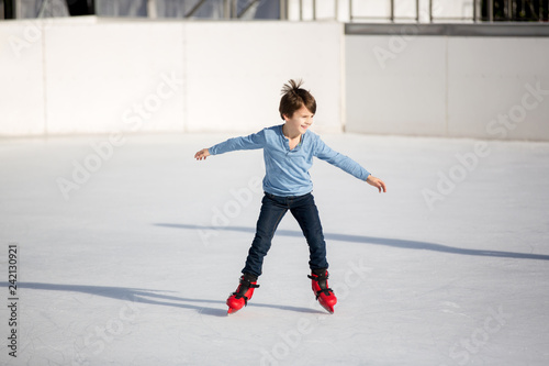 Happy boy with hat and jacket, skating during the day, having fun .