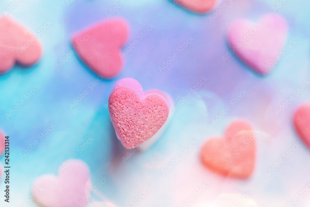 Stacked colorful pastel sugar candies on blue background. Watercolor effect. Valentine Mother's Day kids charity concept. Top view. Greeting card poster banner template