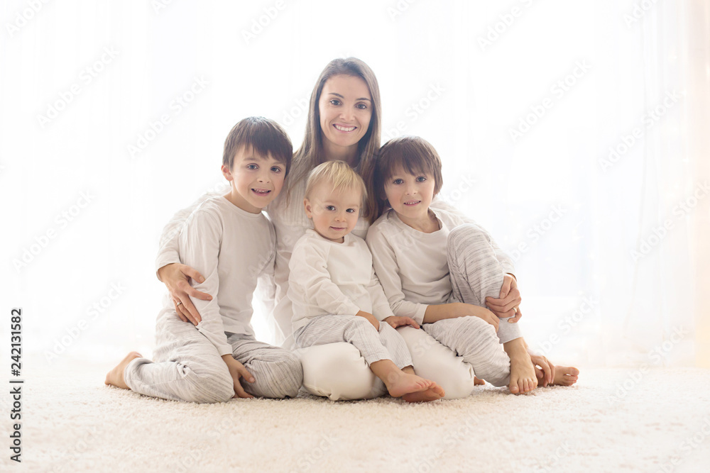 Family portrait of mother and her three boys, isolated on white, back light Family portrait of mother and her three boys, isolated on white, back light