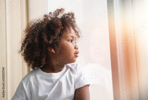 Small child little girl Curly hair near the window
