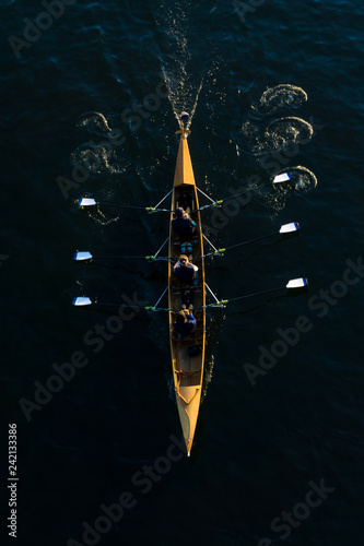 Rudermannschaft in einem Ruderboot. Kanuten in einem Kanu von oben.