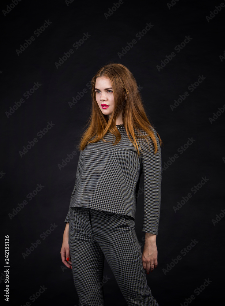 Red-haired girl with long hair in a pantsuit.