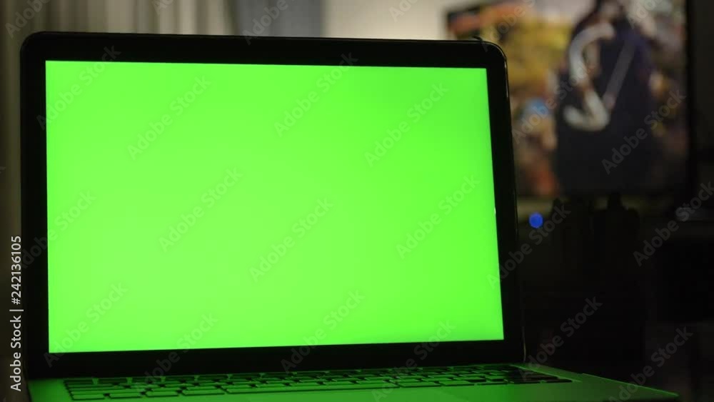 Laptop with green screen. Dark home office . Dolly shot of Perfect to put your own image or video. Laptop with green screen. Dark home office . Dolly shot of Perfect to put your own image or video.