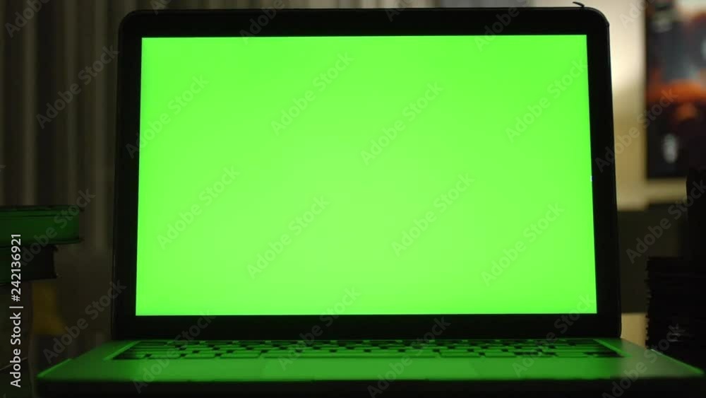 Laptop with green screen. Dark home office . Dolly shot of Perfect to put your own image or video. Laptop with green screen. Dark home office . Dolly shot of Perfect to put your own image or video.