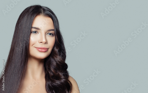 Healthy woman with straight and curly hair on blue background with copy space. Hair styling and hair care concept.