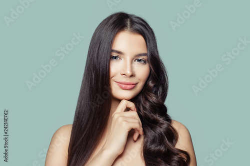 Hair styling and hair care concept. Young brunette woman with straight and curly hair photo