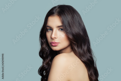 Beautiful female face. Young beauty. Brunette woman on blue background