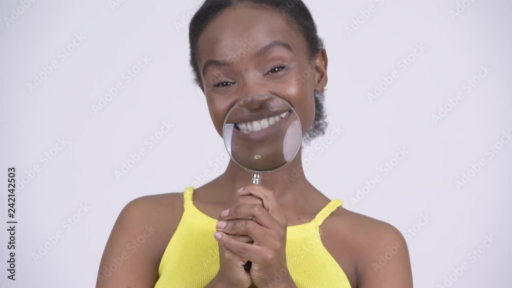 Young happy African woman playing with magnifying glass Young happy African woman playing with magnifying glass