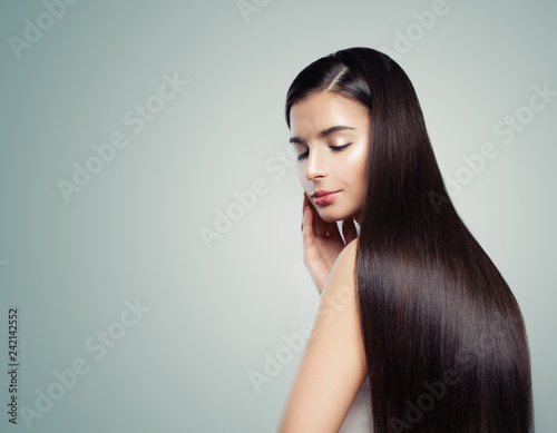 Haircare concept. Perfect woman with long shiny straight hairstyle on blue background with copy space, fashion portrait