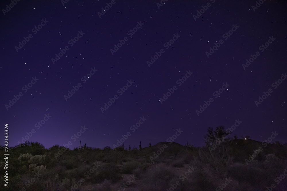 The desert at night shows starry skies and wilderness landscape east of Phoenix, Arizona. Light pollution is making shooting these night scapes more difficult to find dark skies without city glare
