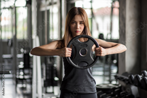 Fitness woman lifting weight in gym