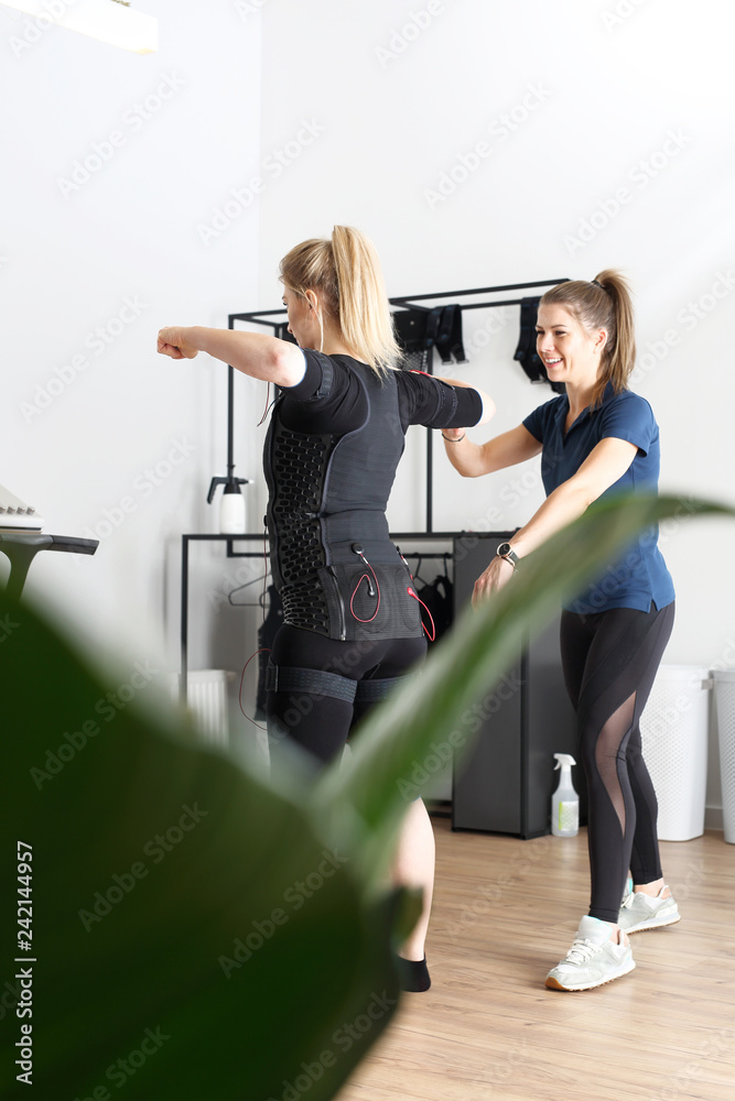 Elektrostymulacja mięśni, trening personalny. Kobieta ćwiczy w specjalnym stroju do stymulacji mięśni. - obrazy, fototapety, plakaty 