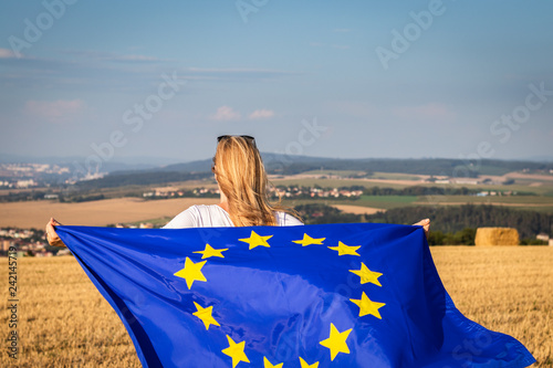 Woman holding waving european union flag in countryside