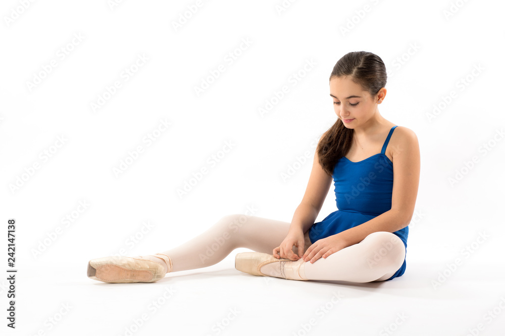 Seated ballerina tying the laces on her shoes Seated ballerina tying the laces on her shoes