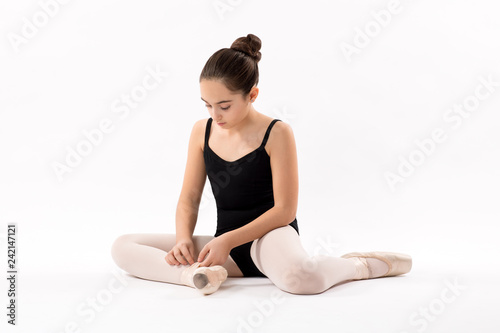 Ballerina tying the laces on her ballet shoes