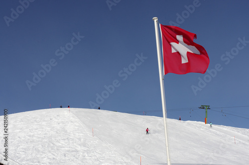 Drapeau suisse flottant au-dessus des pistes de ski