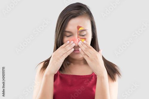 Asian woman in red wear feeling unwell because of sinus against a gray background. People caught a cold and fever. The concept of healthcare and allergy