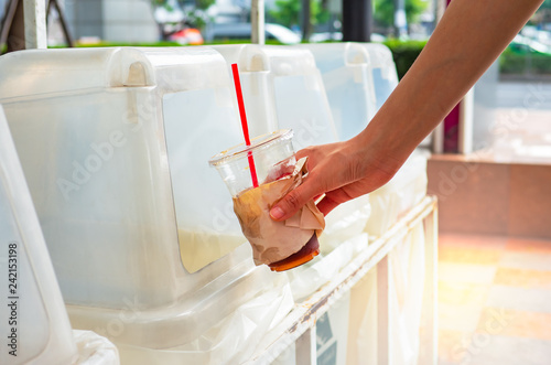 Cup for drink. Hand throwing empty plastic coffee cup into the recycling bin. Disposal of recyclable and reusable garbage. Keep streets, city, earth clean. Eco friendly approach concepts.