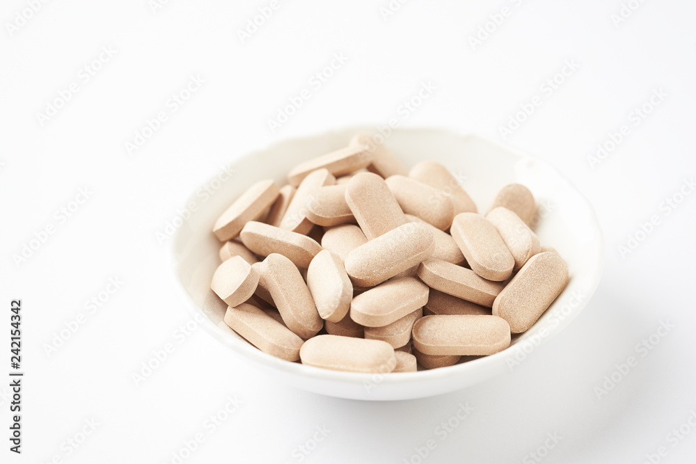 Rhodiola rosea. Golden root, rose root. Herbal pills with healthy medical plant. Healthy supplement on white background. Close up. Rhodiola rosea. Golden root, rose root. Herbal pills with healthy medical plant. Healthy supplement on white background. Close up.
