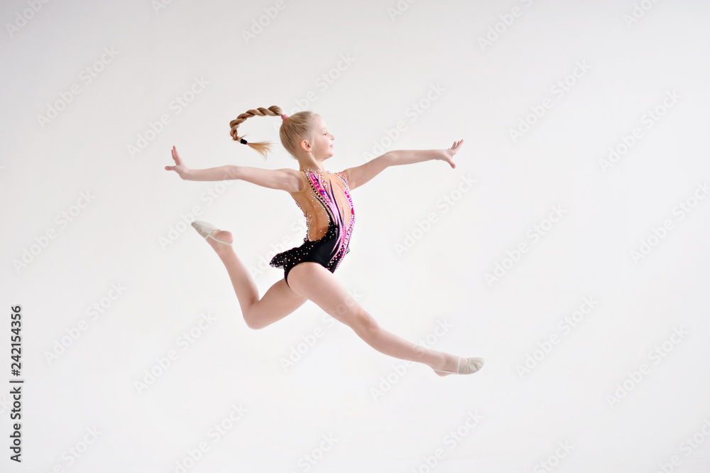 Little girl gymnast, performs various gymnastic and fitness exercises.