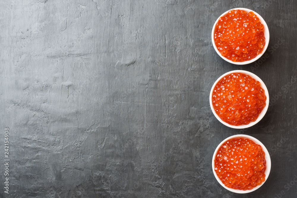 red salmon caviar in a plate on a dark table. Copy space red salmon caviar in a plate on a dark table. Copy space