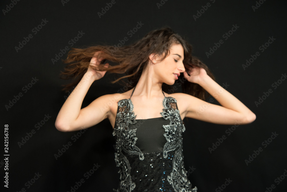 Model with black dress with lace insert. Splendid elegant look that will shine on every occasion. Young beautiful girl with closed eyes. Dream concept. Hands in the hair.