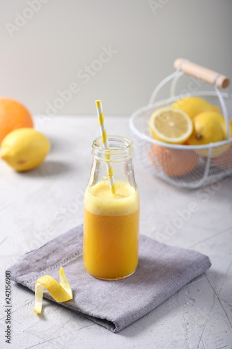 Fresh citrus juice in a bottle with different citrus fruits, healthy vitamin drink