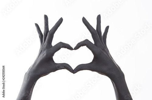Black painted woman's hand doing heart symbol. Symbol of love, declaration of love. Woman Doing heart shape