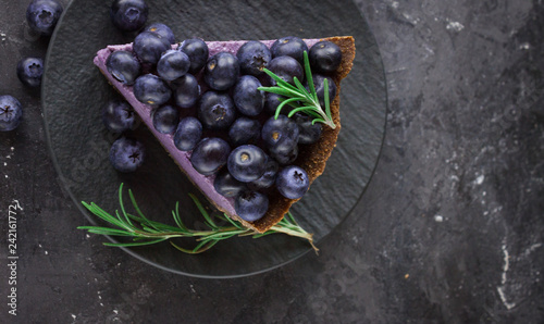 Blueberry vegan cheesecake. Dark photo on black background photo