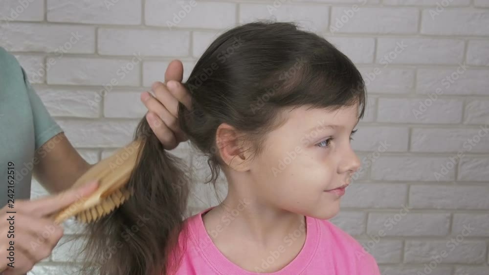Parent making ponytail. Mother combing her little daughter's hair. Parent making ponytail. Mother combing her little daughter's hair.