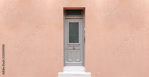 Wooden entrance door, beige color wall background, residential building in old town of Plaka, Athens Greece