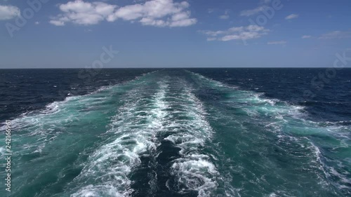 View down the side of a modern cruise ship at the waves created by the motion of the ship