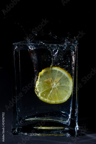 cut lemon splashing on water