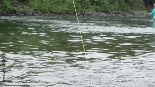 Top of a flyfishing rod in action, in a river somewhere in Canada photo