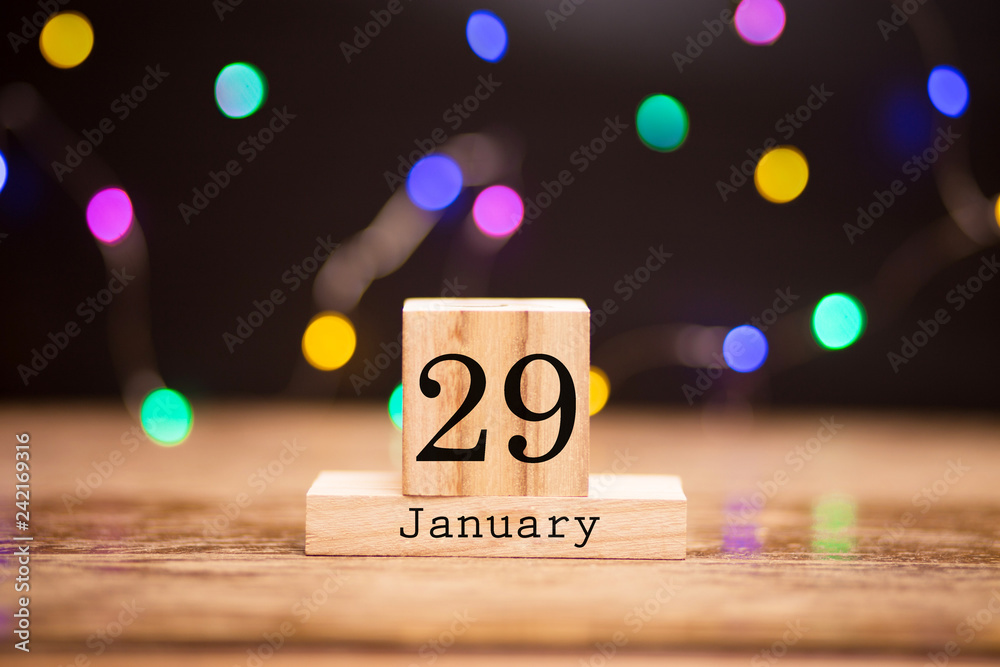 Naklejka premium January 29th. Day 29 of month at center of dark background with garland bokeh. Winter time, year concept.