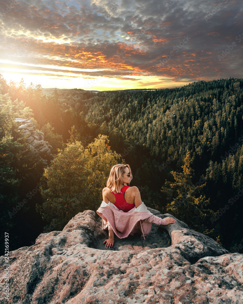 woman sitting on a rock during sunset