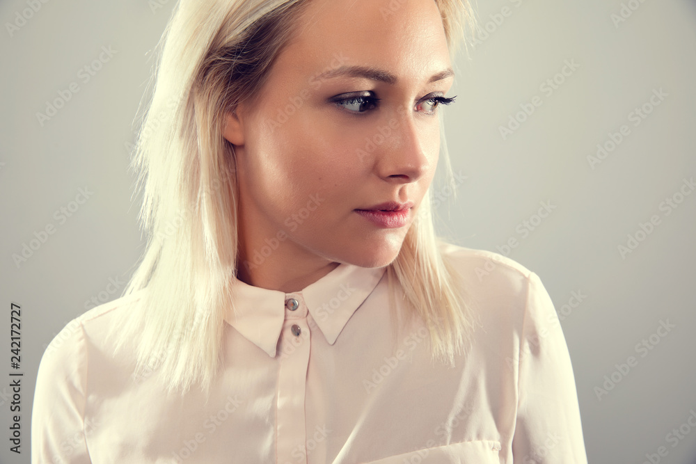 Pensive beautiful female blonde model in shirt looking away from camera Pensive beautiful female blonde model in shirt looking away from camera