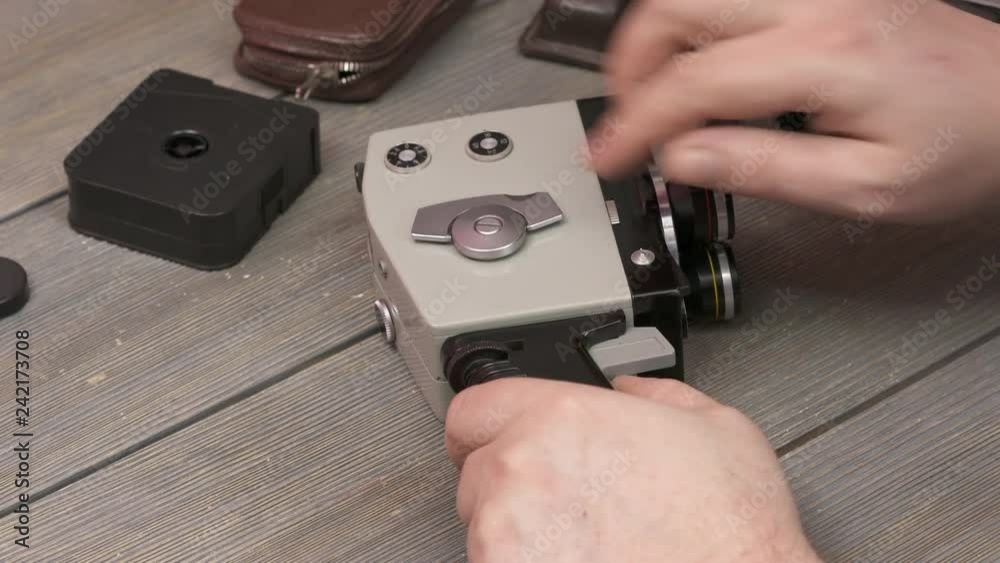 Wincoding Camera Man using vintage 8mm film movie camera. Winding and starting the motor ...