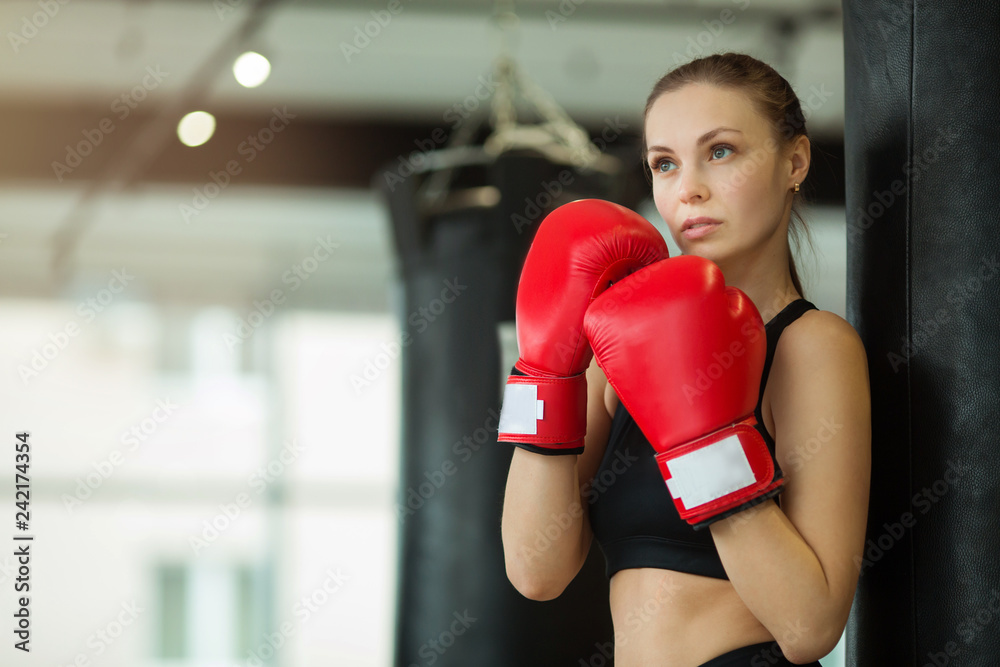beautiful young girl engaged in training in the gym with boxing gloves